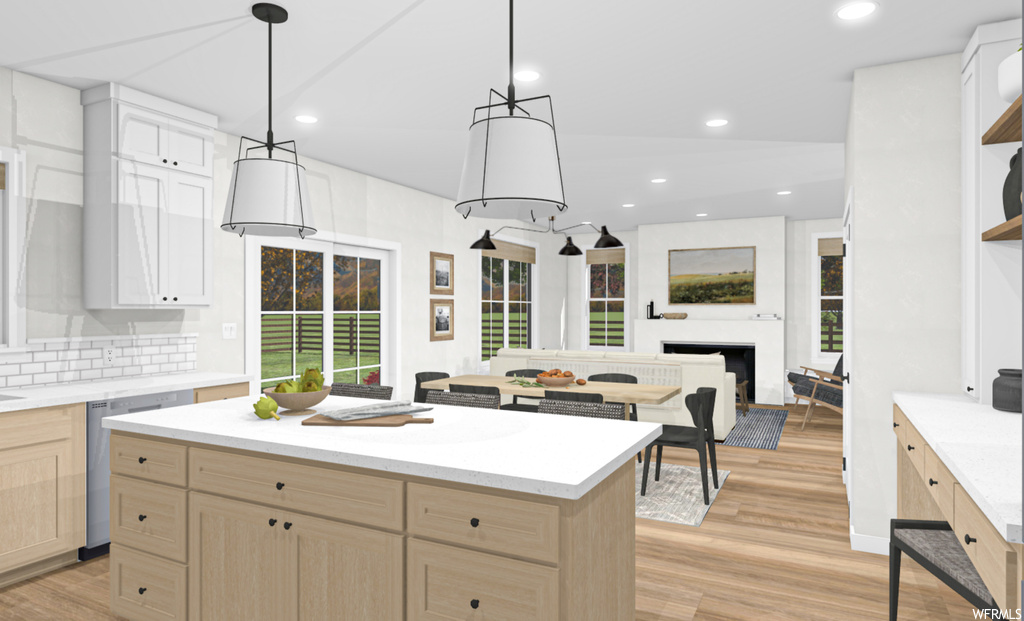Kitchen featuring a fireplace, a kitchen island, a wealth of natural light, light hardwood flooring, light countertops, and pendant lighting