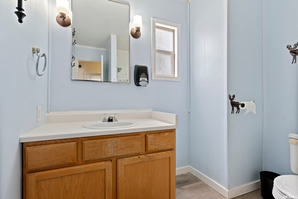 Half bath featuring toilet, mirror, and vanity