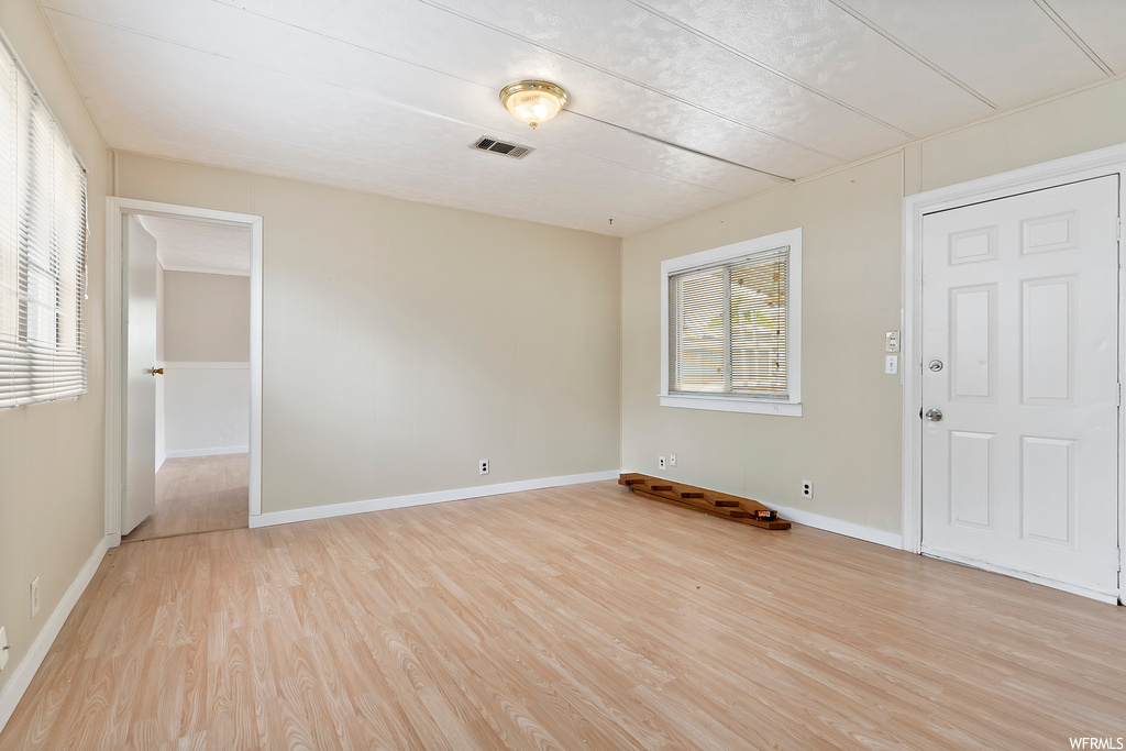 Hardwood floored bedroom with multiple windows