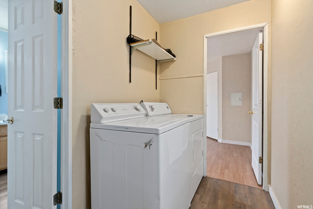 Washroom featuring hardwood floors and separate washer and dryer