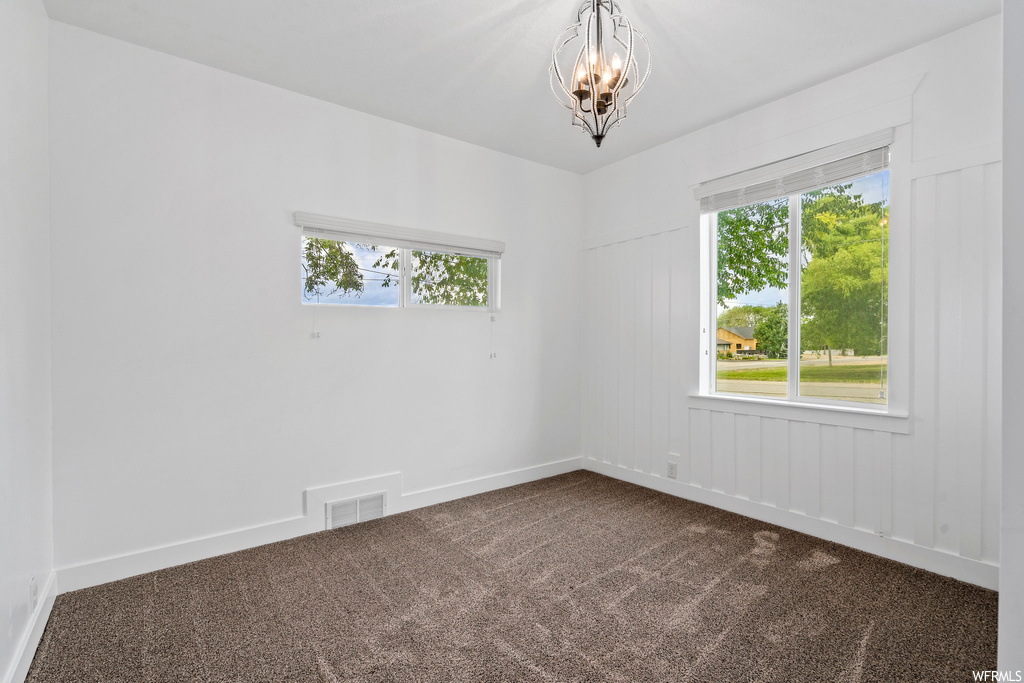 Carpeted spare room featuring natural light