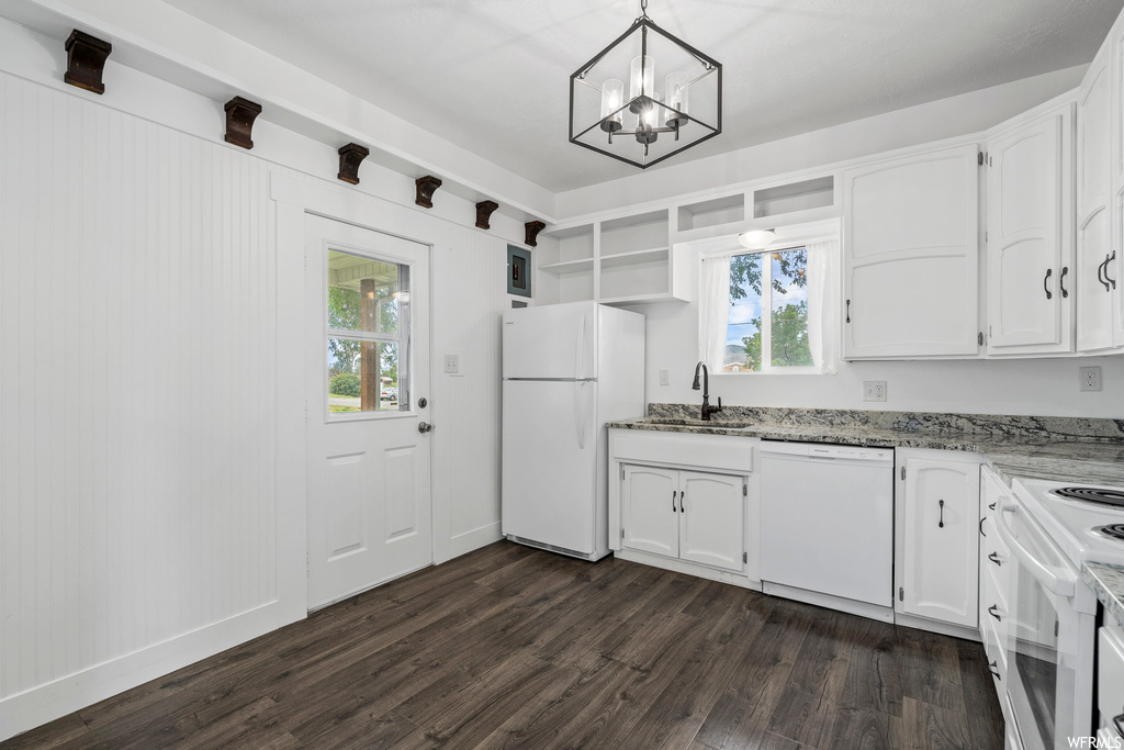 Kitchen featuring natural light, dishwasher, refrigerator, range oven, white cabinets, dark hardwood floors, and light countertops