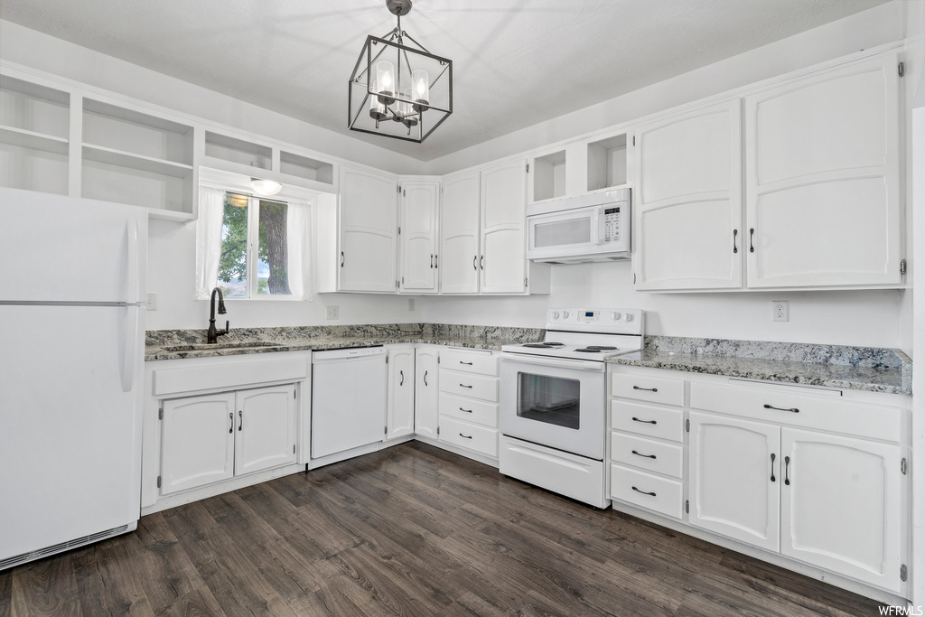 Kitchen featuring hardwood floors, natural light, microwave, dishwasher, refrigerator, electric range oven, and white cabinetry