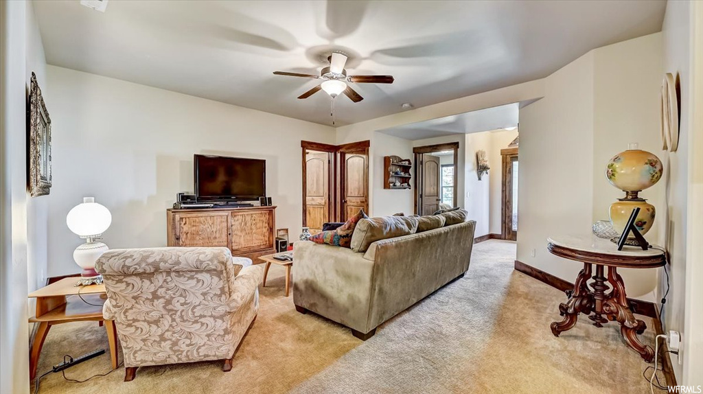 Living room featuring a ceiling fan, carpet, and TV