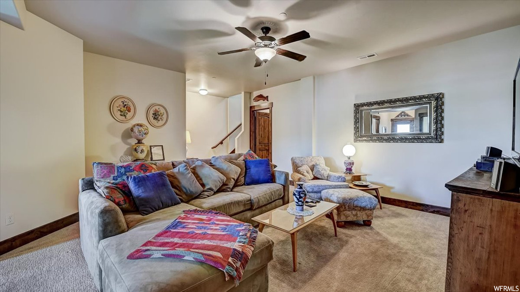 Living room featuring a ceiling fan and carpet