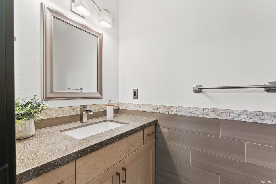 Bathroom featuring mirror and vanity with extensive cabinet space
