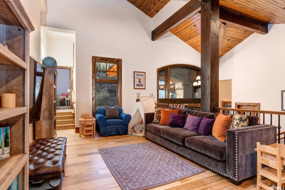 Hardwood floored living room featuring wood beam ceiling