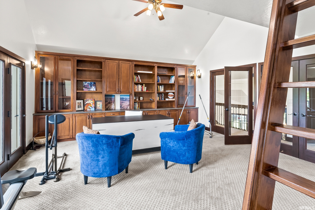 Carpeted home office featuring vaulted ceiling, french doors, and a ceiling fan