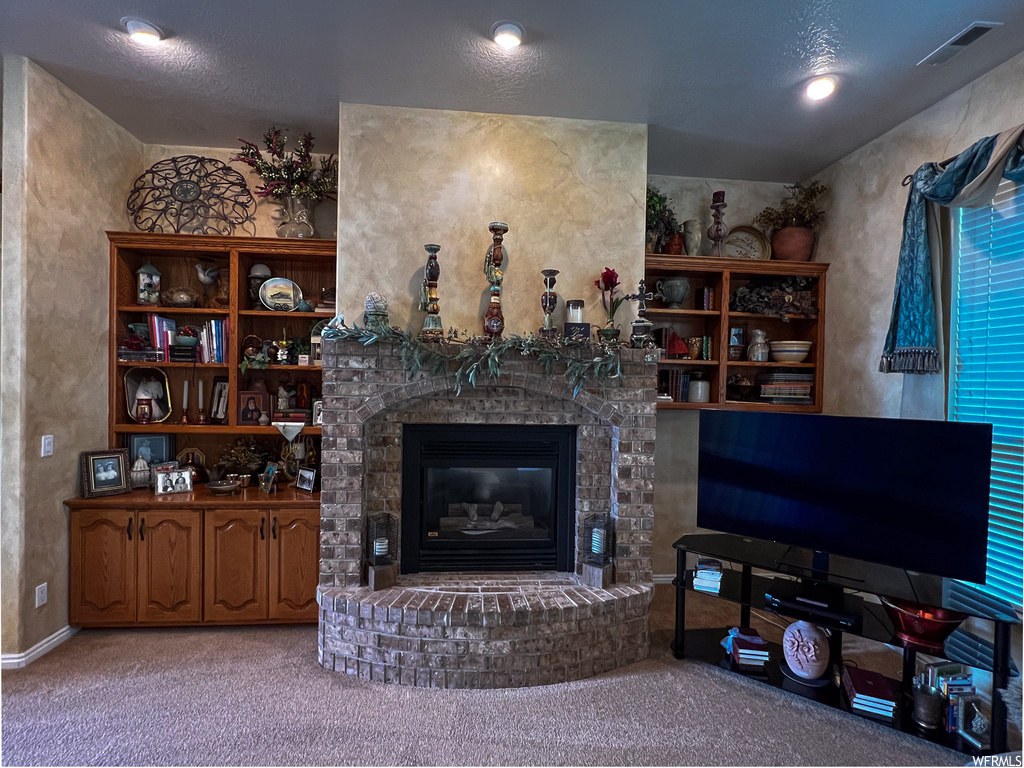 Living room with a fireplace, carpet, and TV