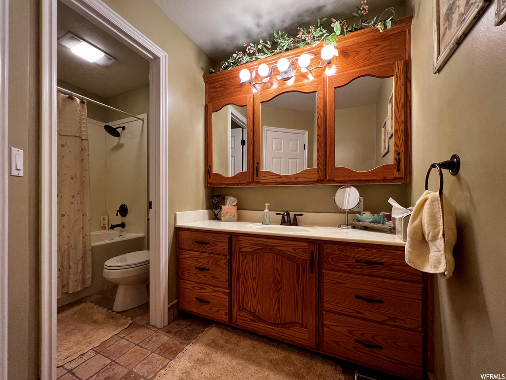 Full bathroom with tile flooring, mirror, tub / shower combination, toilet, shower curtain, and vanity
