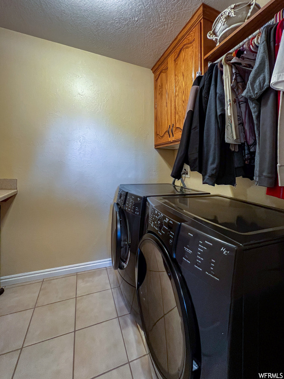 Clothes washing area with tile floors and washer / dryer