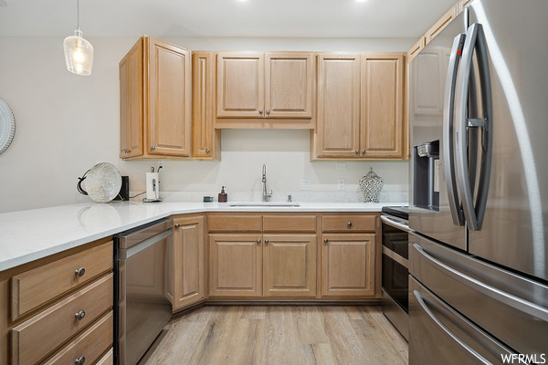 Kitchen featuring refrigerator, range oven, pendant lighting, brown cabinetry, light parquet floors, and light countertops