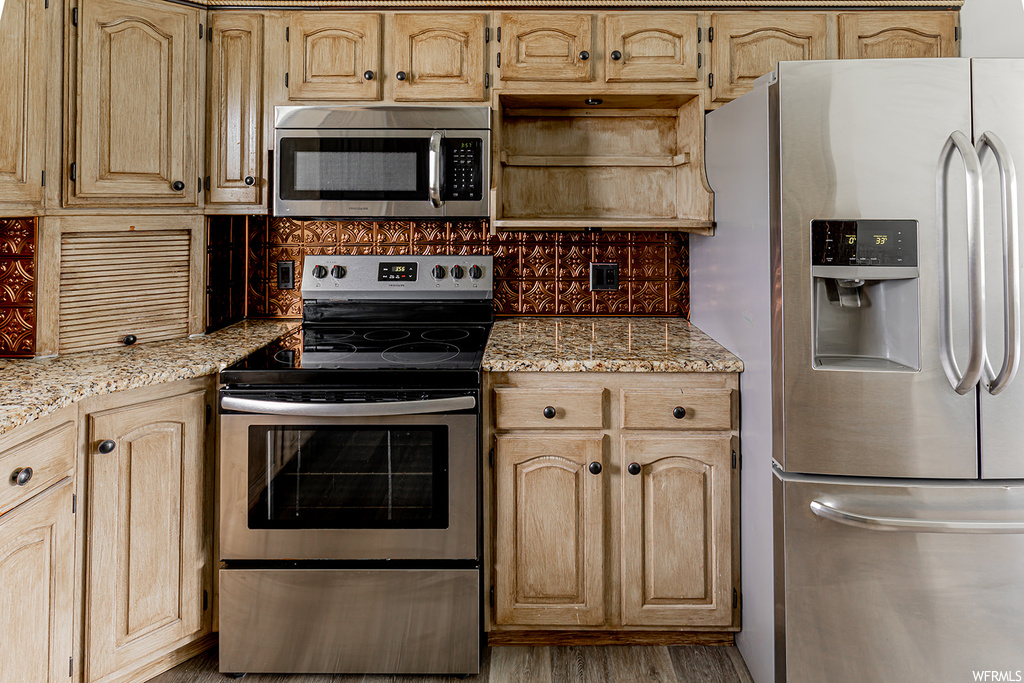 Kitchen with microwave, refrigerator, and electric range oven
