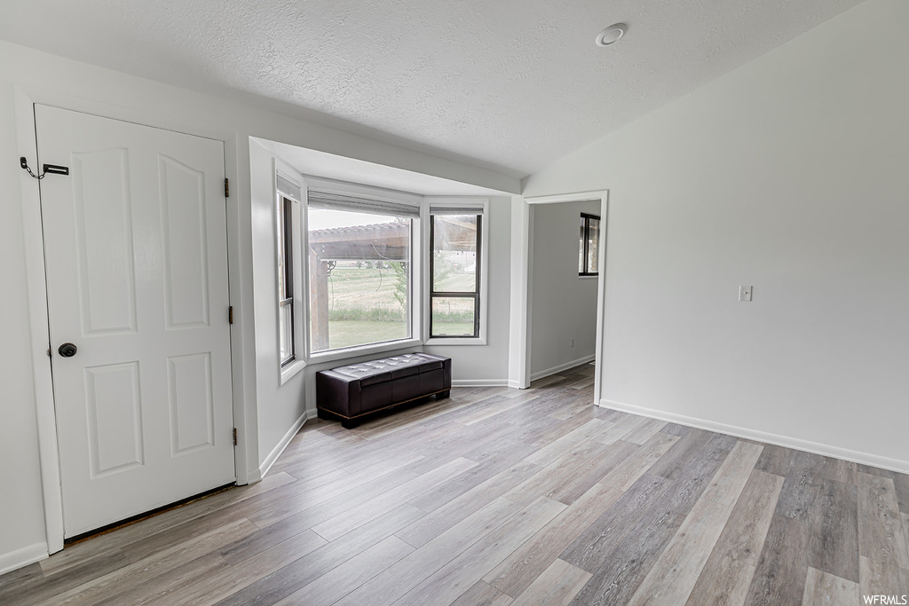 Spare room with hardwood flooring and natural light