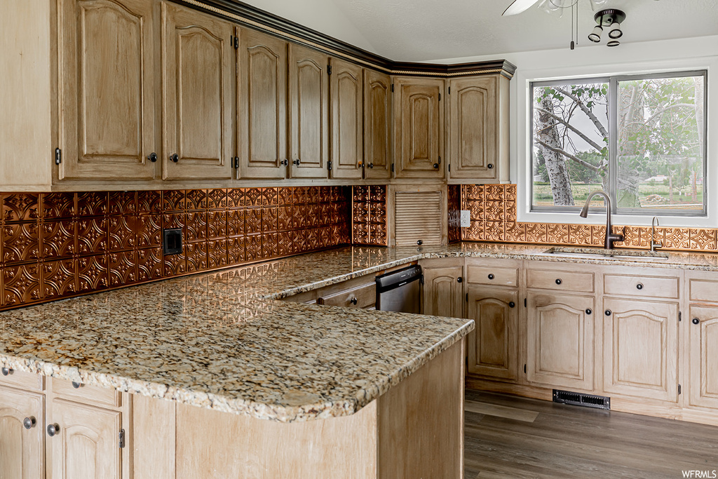 Kitchen with hardwood floors, natural light, dishwasher, and granite-like countertops