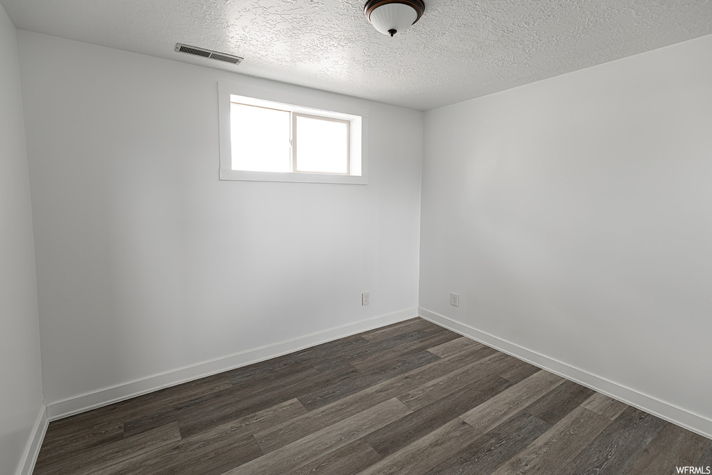 Empty room featuring wood-type flooring and natural light