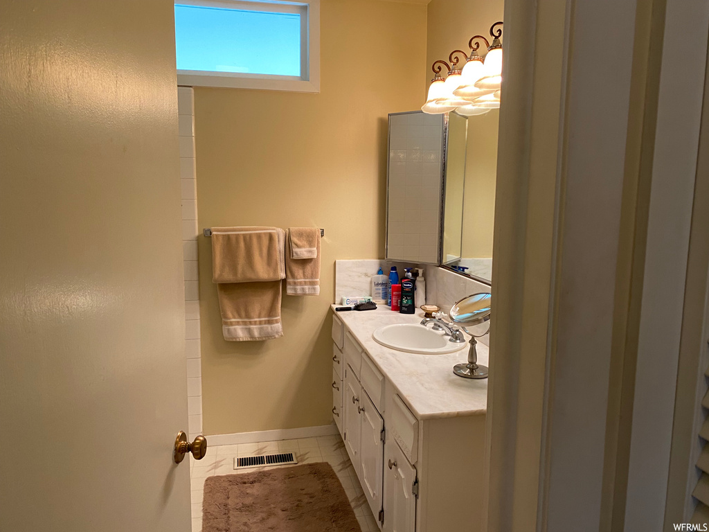 Bathroom with tile flooring, mirror, and oversized vanity