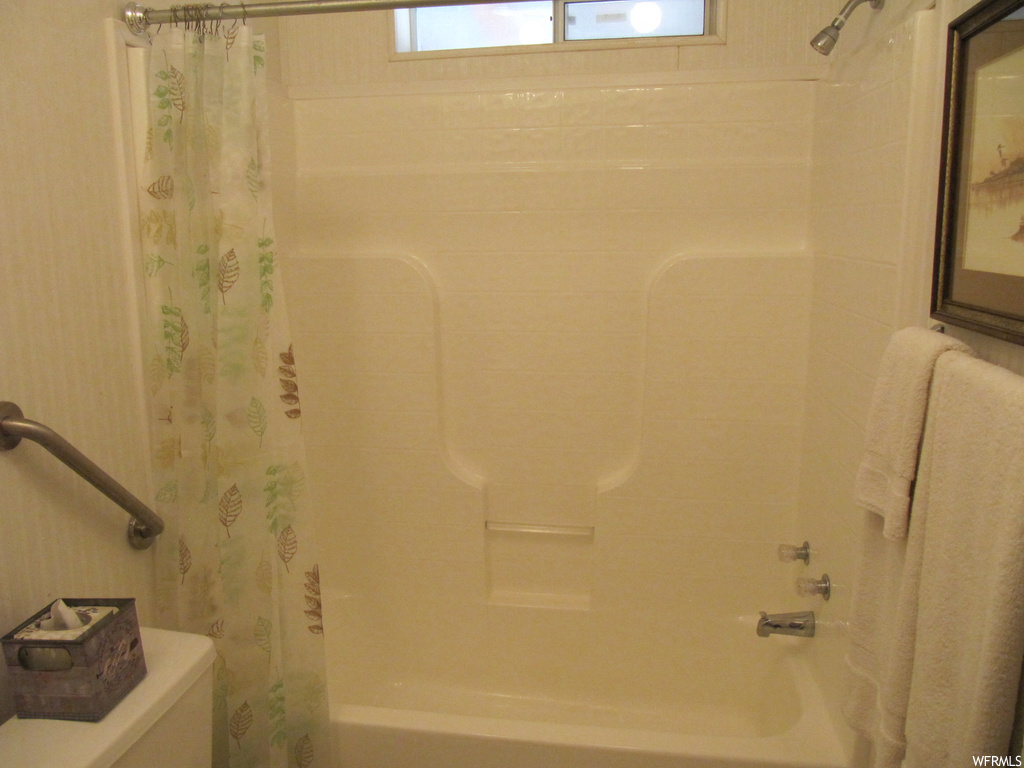 Bathroom featuring shower curtain and shower / bathtub combination