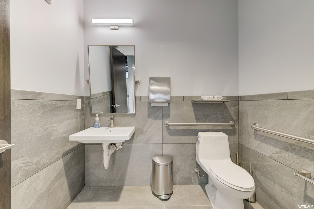 Half bath featuring dual mirrors, toilet, and washbasin