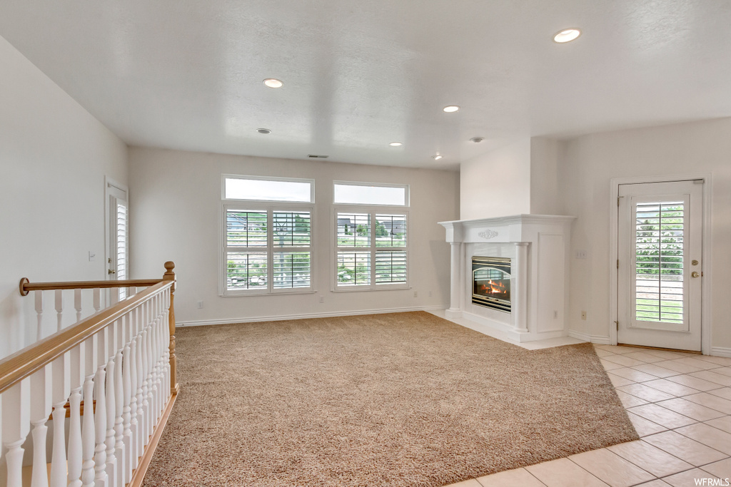 Carpeted living room featuring natural light and a fireplace