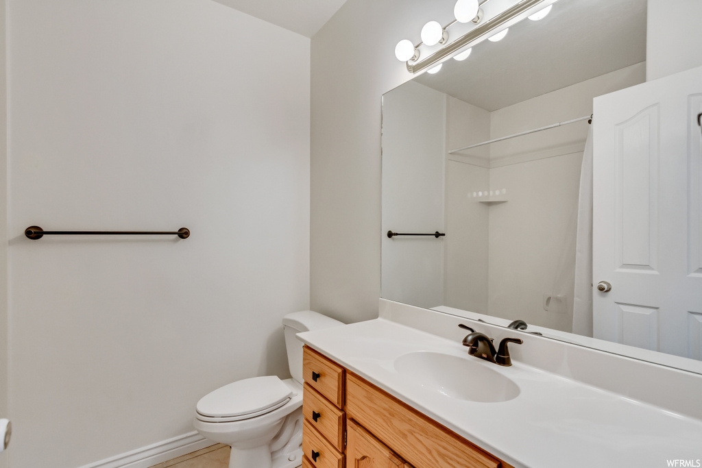 Half bathroom with vanity, mirror, and toilet