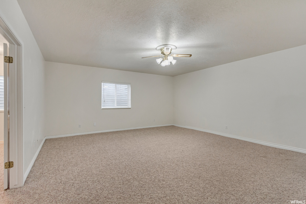 Carpeted empty room with a ceiling fan