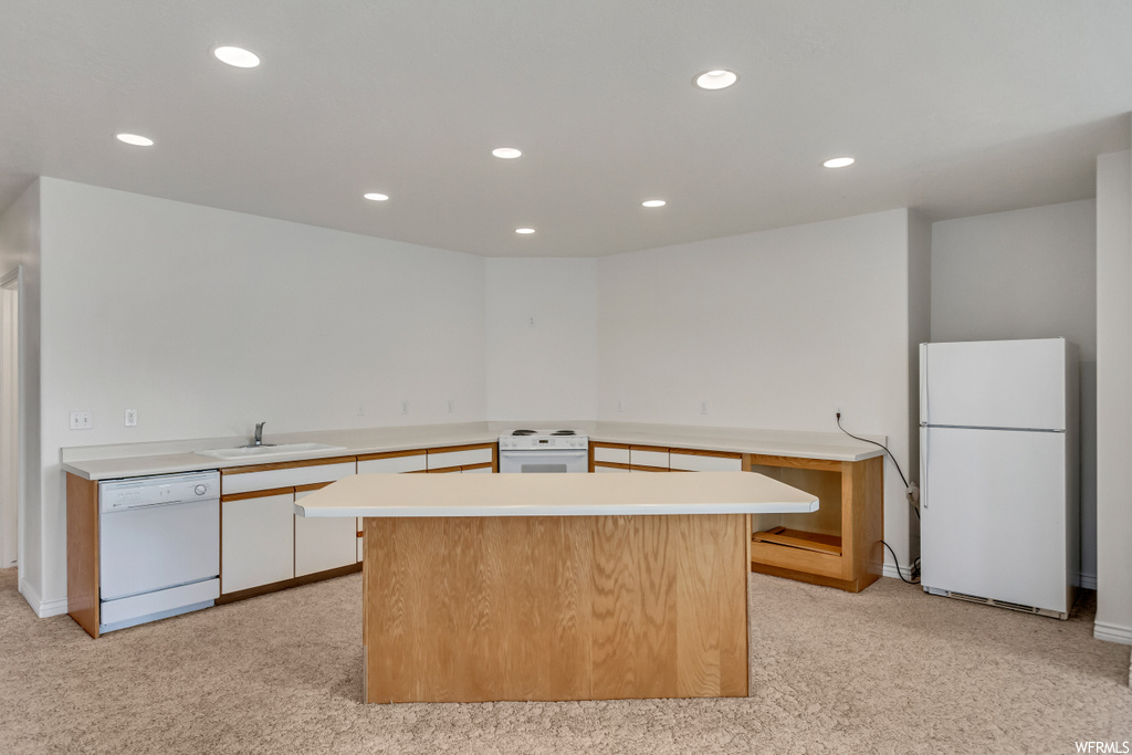 Kitchen featuring dishwasher, refrigerator, range oven, light countertops, and light flooring