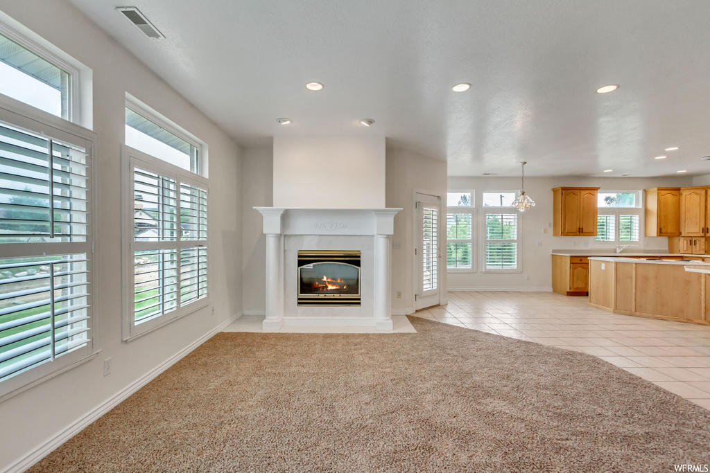 Carpeted living room with natural light and a fireplace