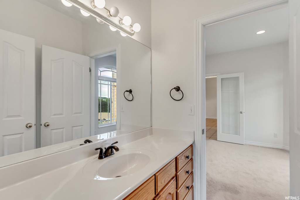 Bathroom featuring natural light, vanity, and mirror