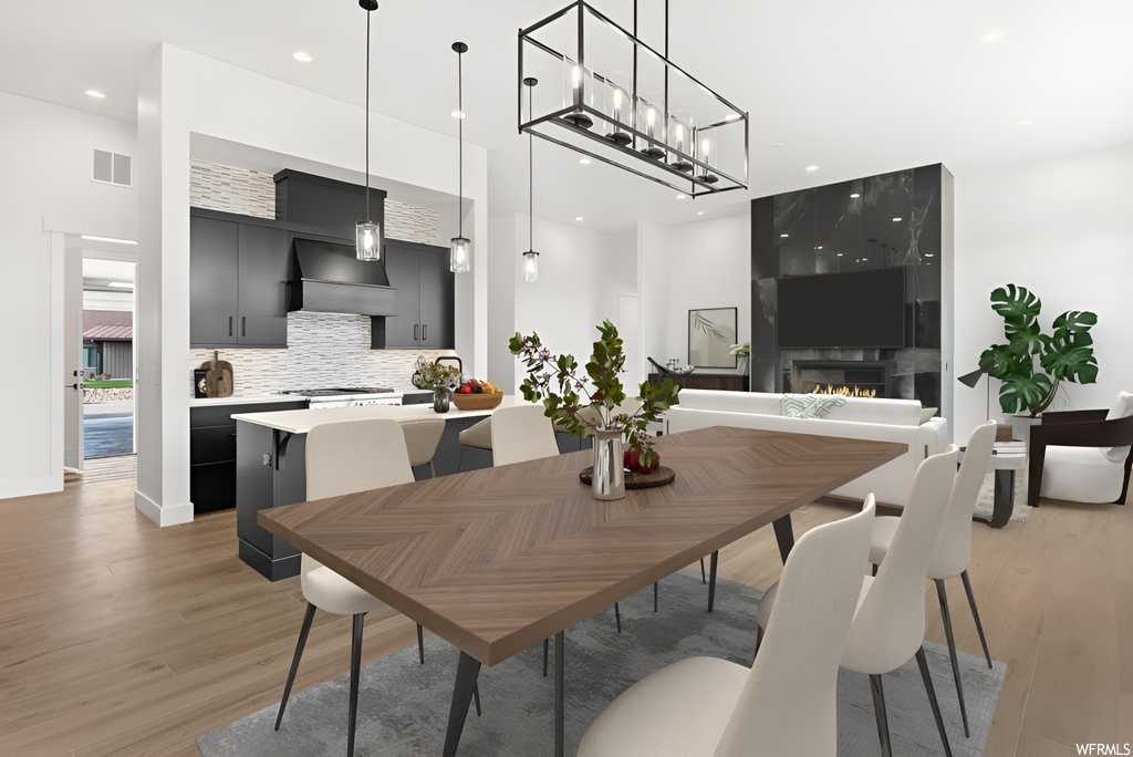 Dining area with hardwood flooring, stainless steel finishes, and TV