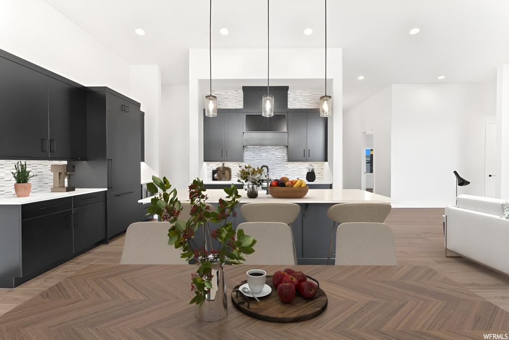 Kitchen with light parquet floors, light countertops, dark brown cabinetry, and pendant lighting