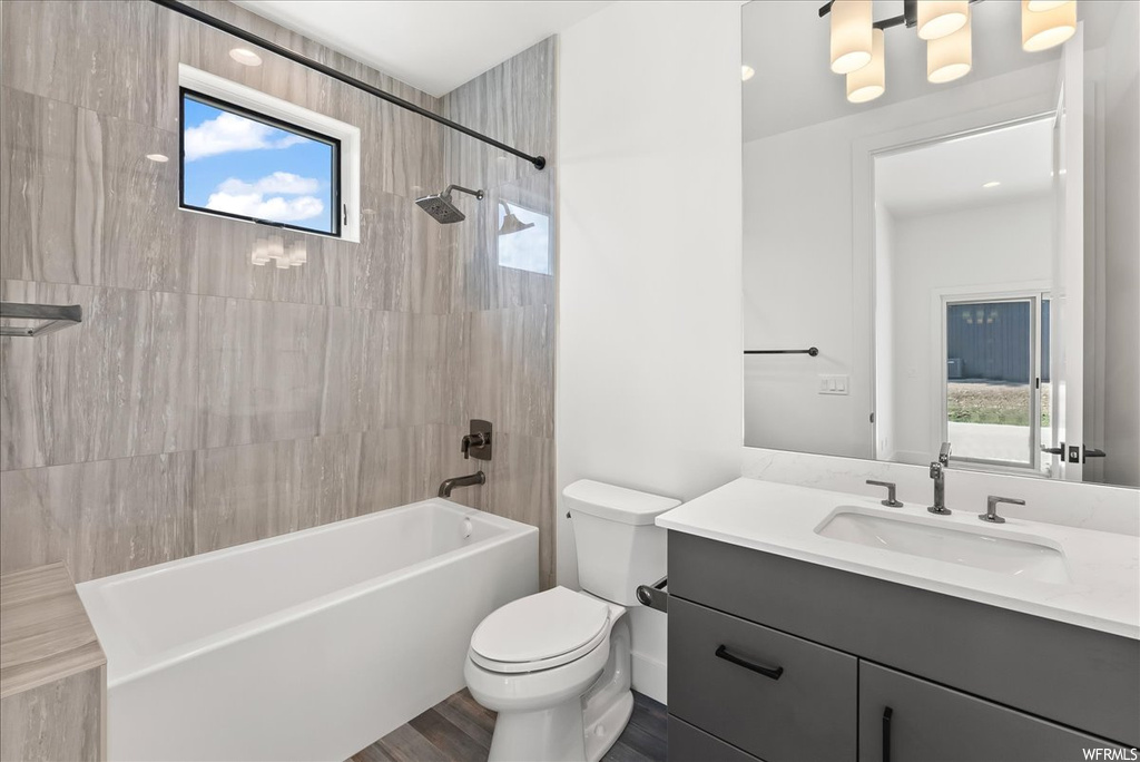Full bathroom featuring natural light, toilet, bathtub / shower combination, mirror, and vanity