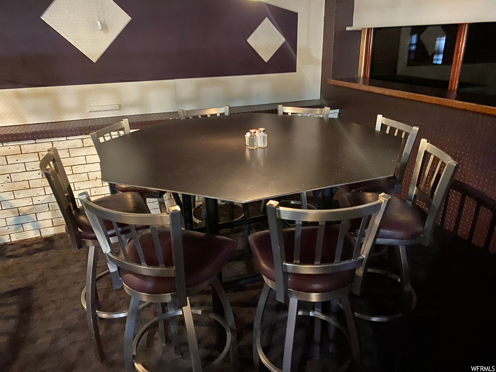 Bar with dark floors and dark countertops