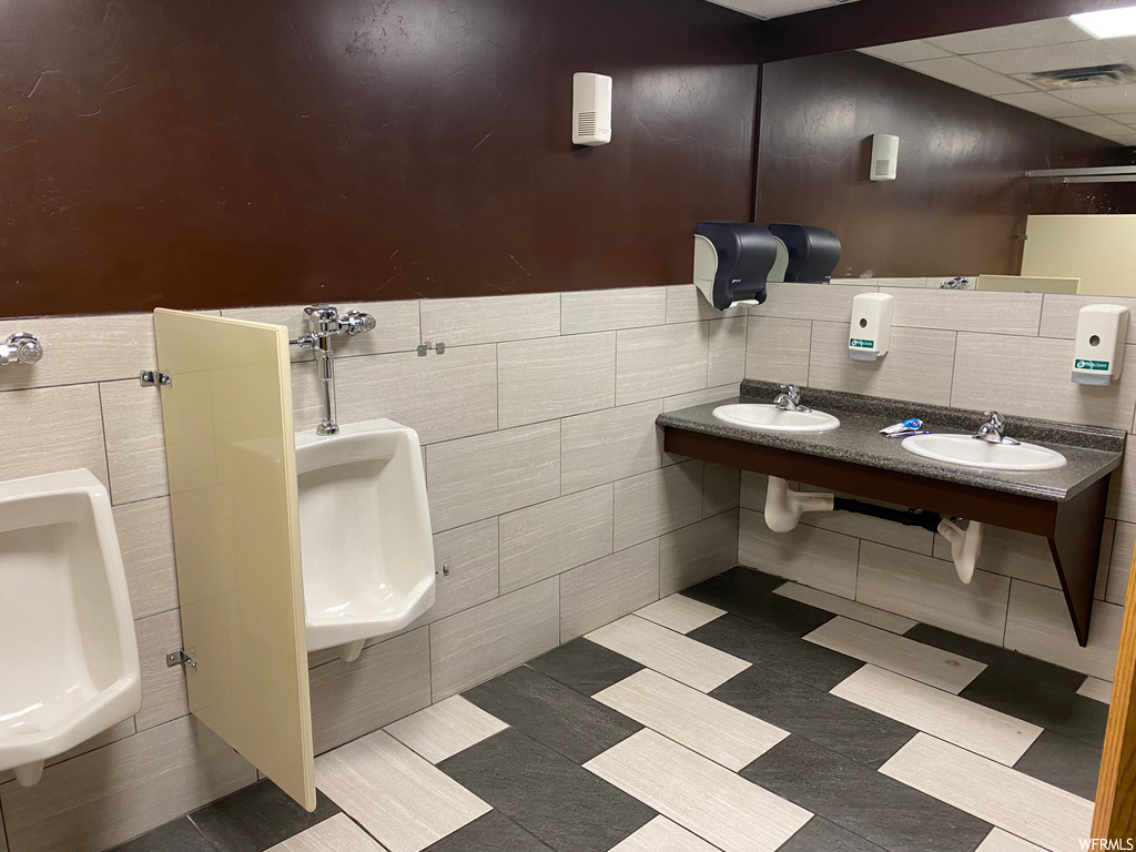 Bathroom with tile floors, double sink, and mirror