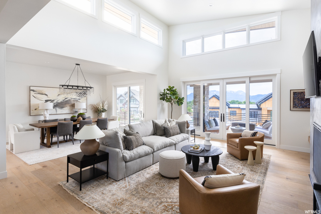 Living room with a high ceiling and light hardwood flooring