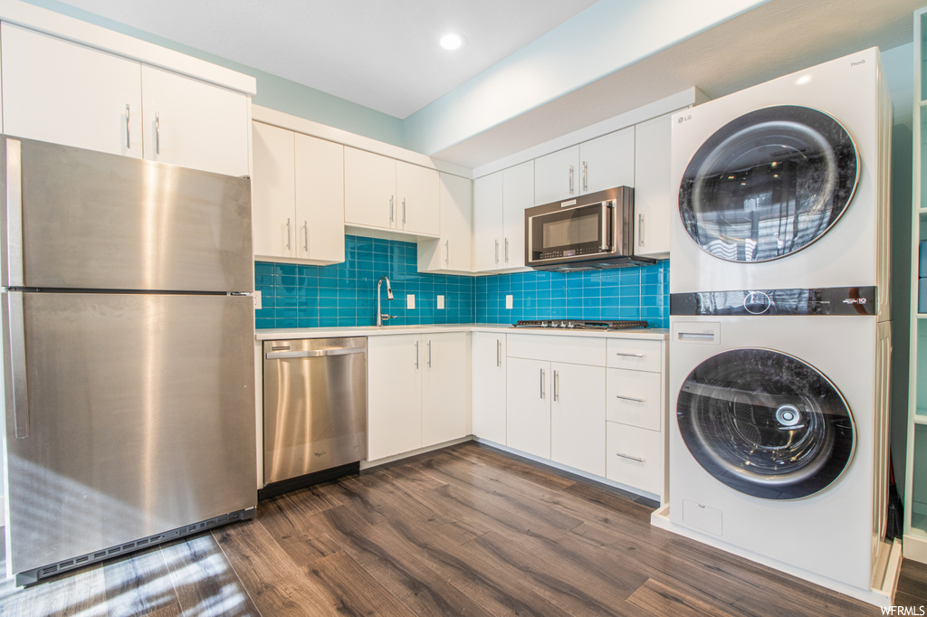 Laundry area featuring hardwood floors, microwave, and independent washer and dryer