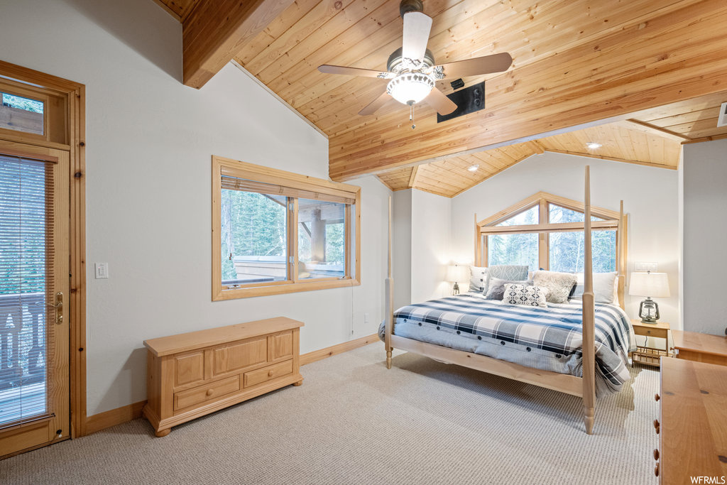 Carpeted bedroom featuring a ceiling fan, multiple windows, and vaulted ceiling