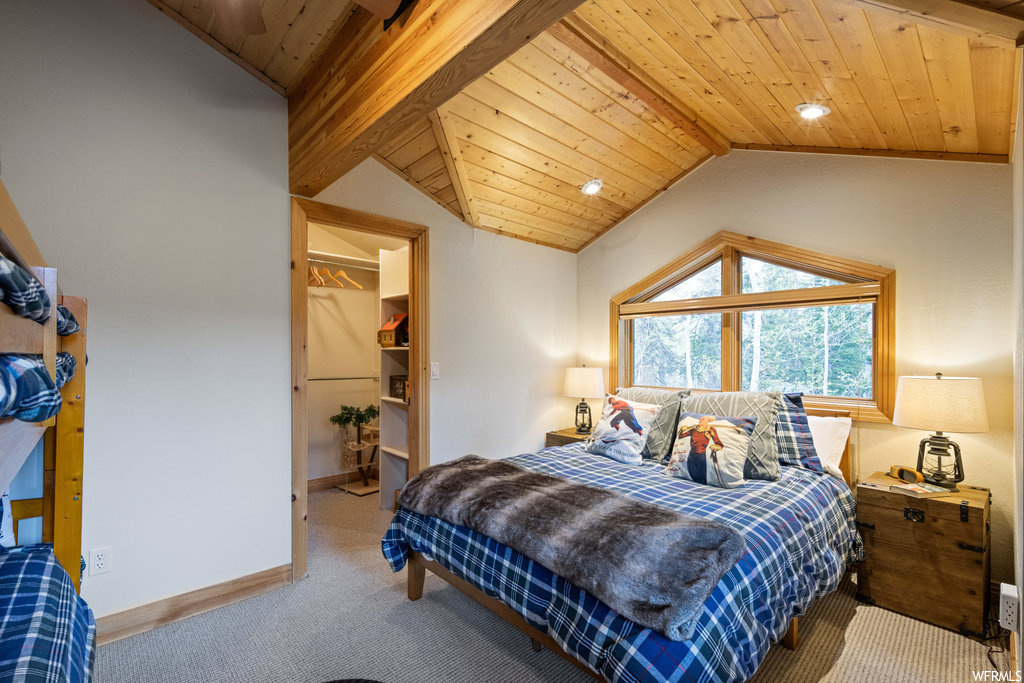 Carpeted bedroom with vaulted ceiling and natural light
