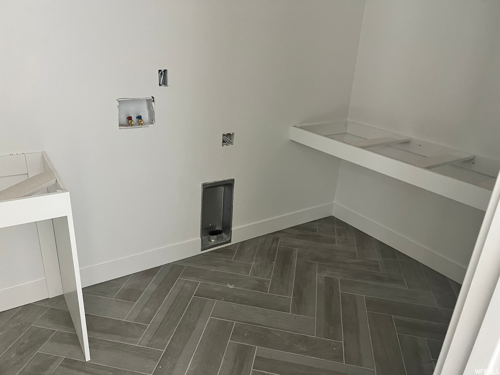 Clothes washing area with dark parquet floors