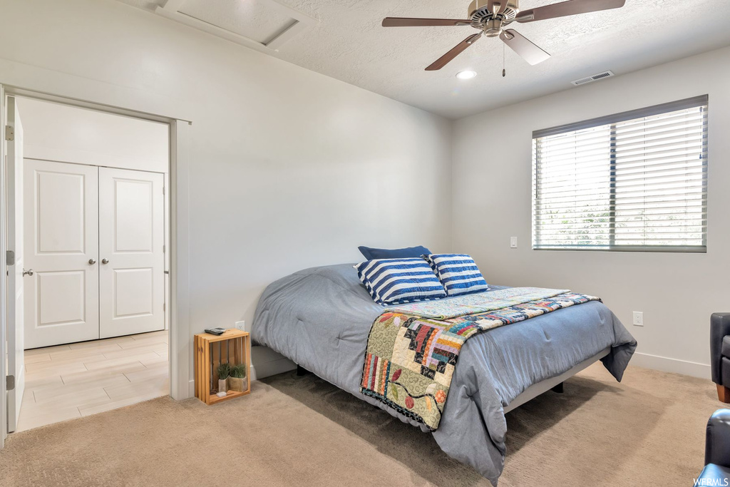 Bedroom featuring natural light, carpet, and a ceiling fan