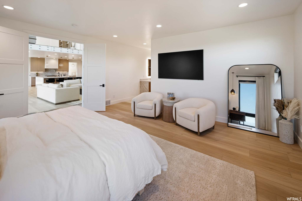Hardwood floored bedroom with TV