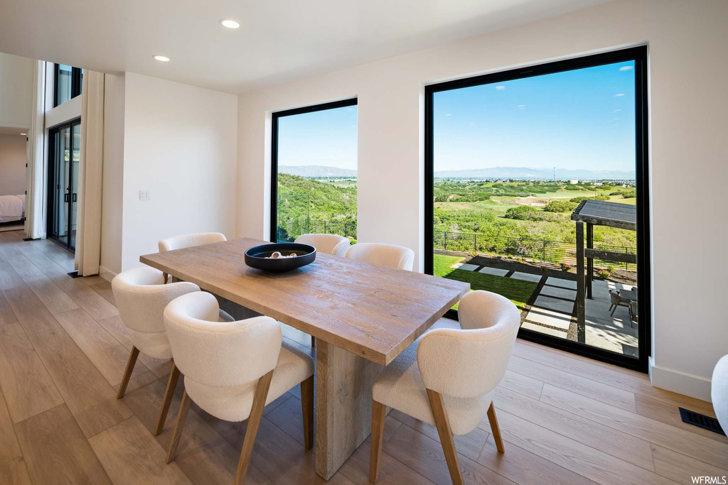 Dining space with a wealth of natural light and hardwood flooring