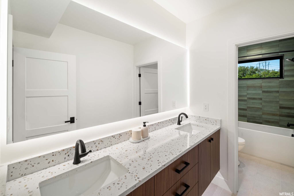 Half bathroom featuring tile floors, mirror, toilet, and double large sink vanity