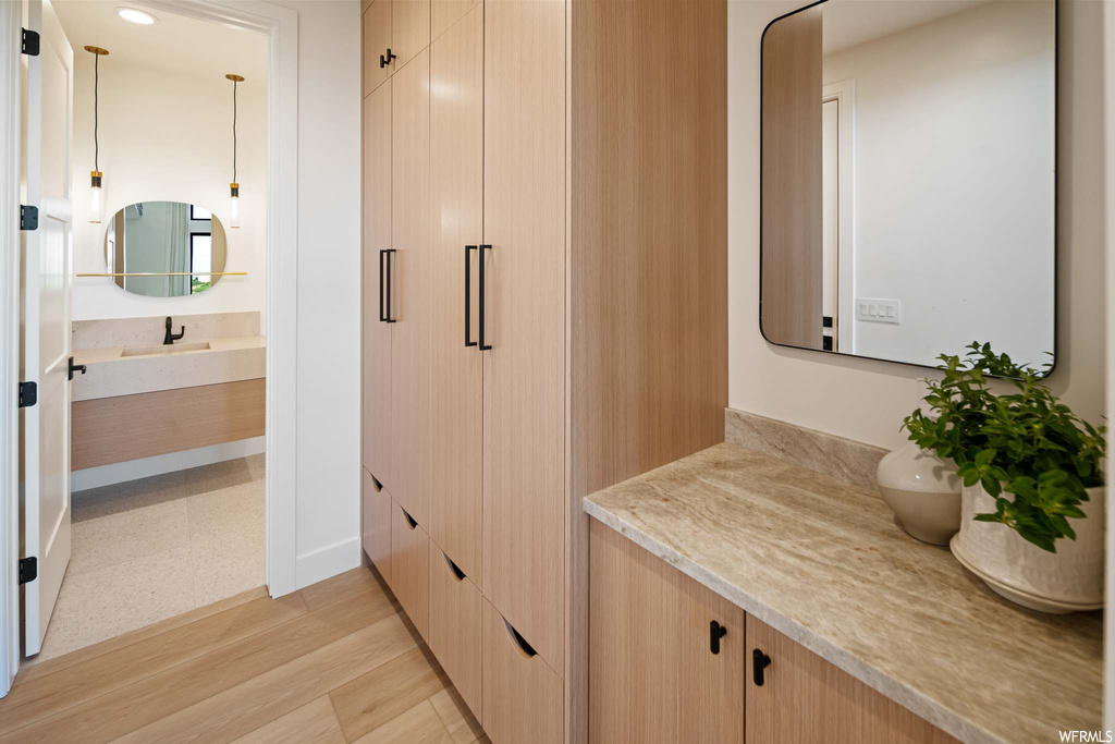Bathroom featuring hardwood flooring, mirror, and vanity