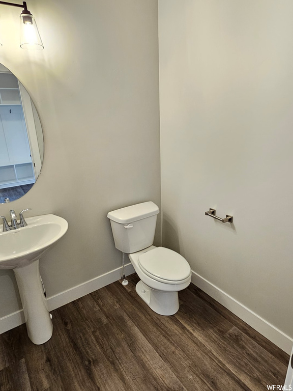 Bathroom featuring wood-type flooring, toilet, and sink