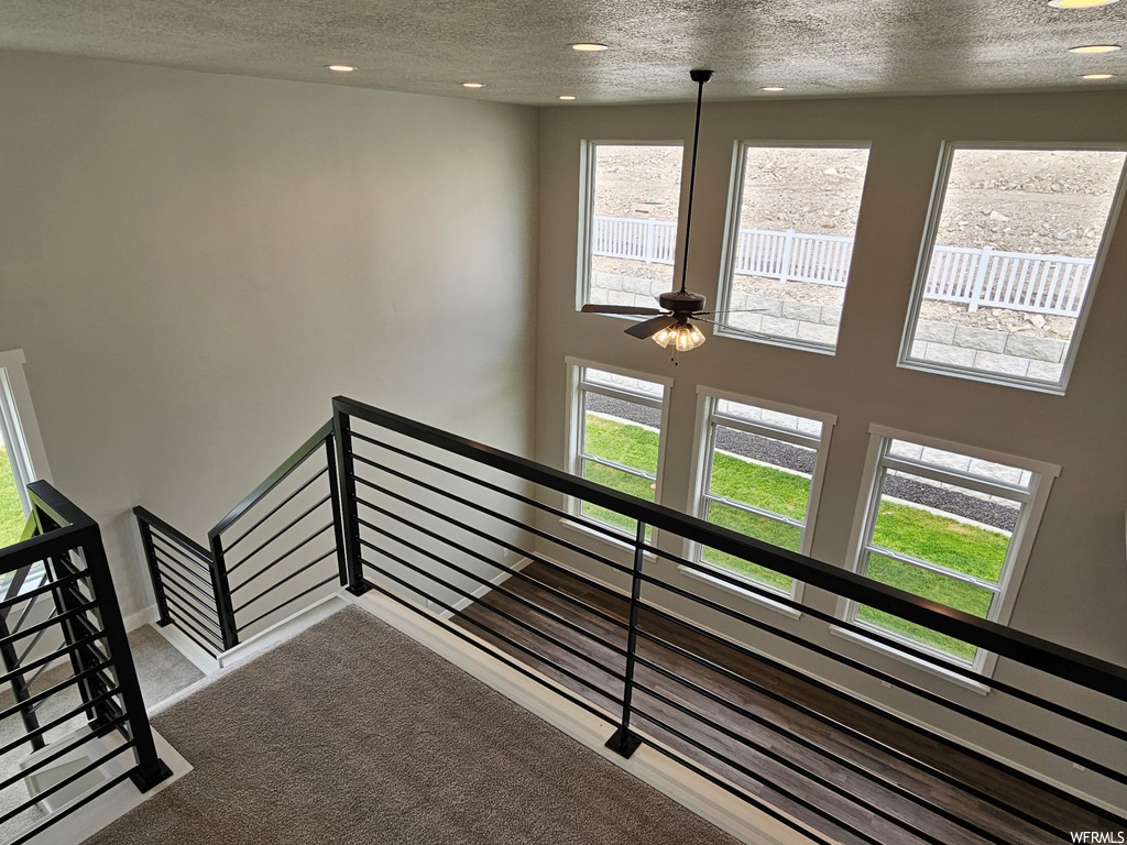 Stairway featuring carpet floors and a textured ceiling