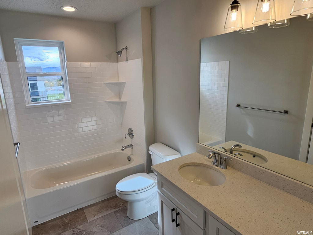 Full bathroom with toilet, a textured ceiling, tile flooring, vanity, and  shower combination