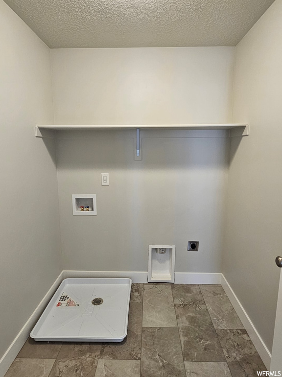 Washroom featuring washer hookup, hookup for an electric dryer, tile floors, and a textured ceiling