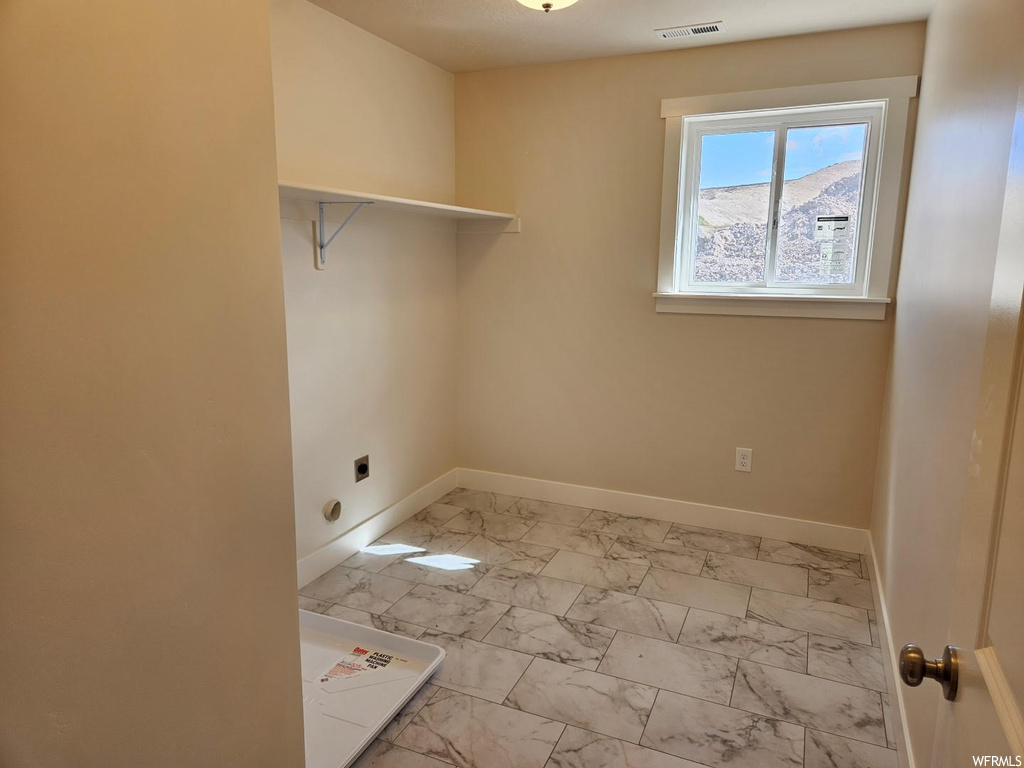 Laundry area featuring natural light and tile floors