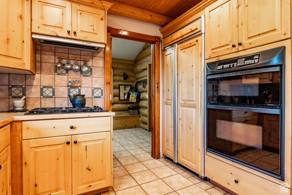 Kitchen with log walls, light tile floors, tasteful backsplash, beam ceiling, and black double oven